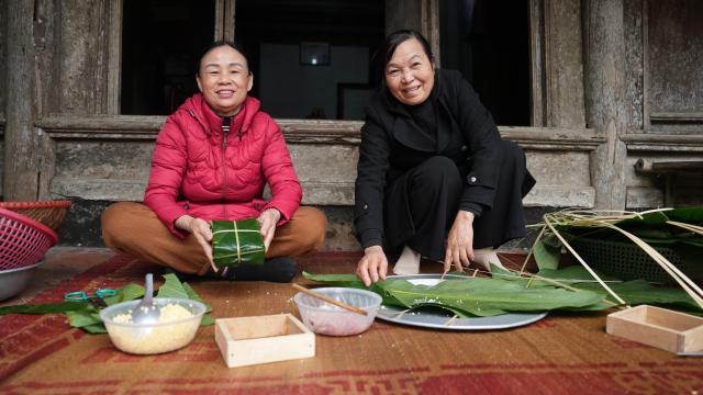 (260211) -- HANOI, Feb. 11, 2026 (Xinhua) -- Do Thi Minh Nguyet and her relative make square glutinous rice cakes in Duong Lam of Hanoi, Vietnam, Feb. 9, 2026. TO GO WITH: "Feature: Ancient Vietnamese village opens doors for tourists to explore Lunar New Year customs" (Xinhua/Hu Jiali)