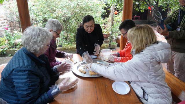 (260211) -- HANOI, Feb. 11, 2026 (Xinhua) -- Do Thi Minh Nguyet instructs foreign visitors in making spring rolls in Duong Lam of Hanoi, Vietnam, Feb. 9, 2026. TO GO WITH: "Feature: Ancient Vietnamese village opens doors for tourists to explore Lunar New Year customs" (Xinhua/Hu Jiali)