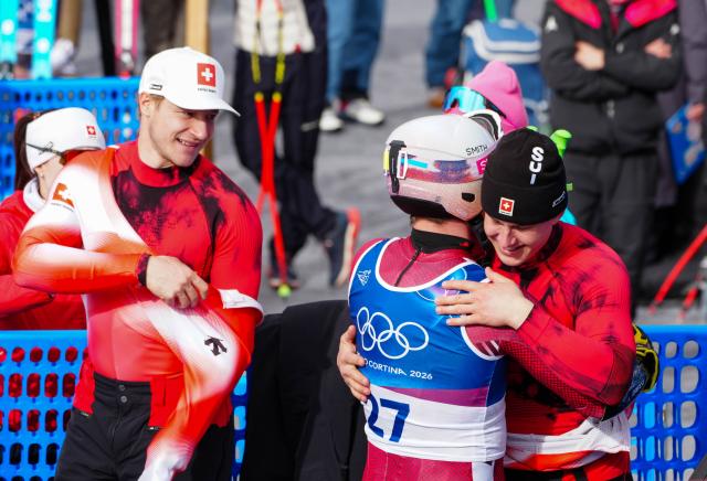 (260211) -- BORMIO, Feb. 11, 2026 (Xinhua) -- Franjo von Allmen (R) of Switzerland hugs Brodie Seger (C) of Canada after the alpine skiing men's Super-G at the Milan-Cortina 2026 Olympic Winter Games in Bormio, Italy, Feb. 11, 2026. (Xinhua/Yan Linyun)