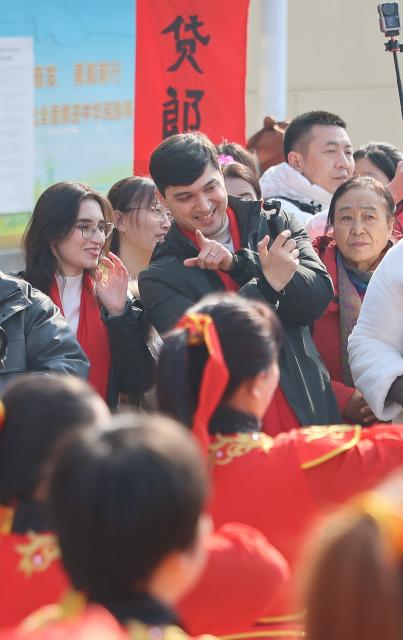(260211) -- TIANJIN, Feb. 11, 2026 (Xinhua) -- Suleimanov Umar (C) films a video in Chuanfangyu Town of Jizhou District, north China's Tianjin, Feb. 10, 2026. On the occasion of traditional Chinese Xiaonian Festival in northern China, which fell on Tuesday this year, Suleimanov Umar, a 26-year-old Tajikistan student in Nankai University of Tianjin, and other international students visited a local festive fair in Chuanfangyu Town to experience the vibrant traditions of Chinese New Year. Celebrated on the 23rd day of the last month of the Chinese lunar calendar, Xiaonian is a festival marking the start of the countdown to the Chinese New Year.
   When Suleimanov was a child, most neighbors were Chinese working in Tajikistan, thus he was deeply impressed by Chinese New Year traditions such as putting up Spring Festival couplets and making dumplings.
   When in middle school, he began studying Chinese at local Confucius Institute, and then chose to go to university in China with the support of his family. While staying in China he immersed himself in social practice and actively participated in cultural exchange activities.
    Speaking of the future, Suleimanov said, "I hope I could engage in diplomatic work after graduation and strive to become an envoy of friendship". (Xinhua/Li Ran)