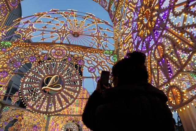 (260211) -- SEOUL, Feb. 11, 2026 (Xinhua) -- A visitor takes photos during a light festival ahead of Lunar New Year around the Lotte World Tower in Seoul, South Korea, Feb. 11, 2026. (Photo by Jun Hyosang/Xinhua)