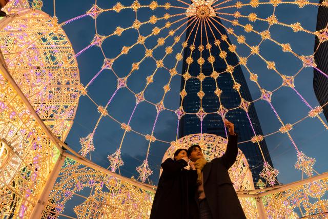 (260211) -- SEOUL, Feb. 11, 2026 (Xinhua) -- People take selfies during a light festival ahead of Lunar New Year around the Lotte World Tower in Seoul, South Korea, Feb. 11, 2026. (Photo by Jun Hyosang/Xinhua)