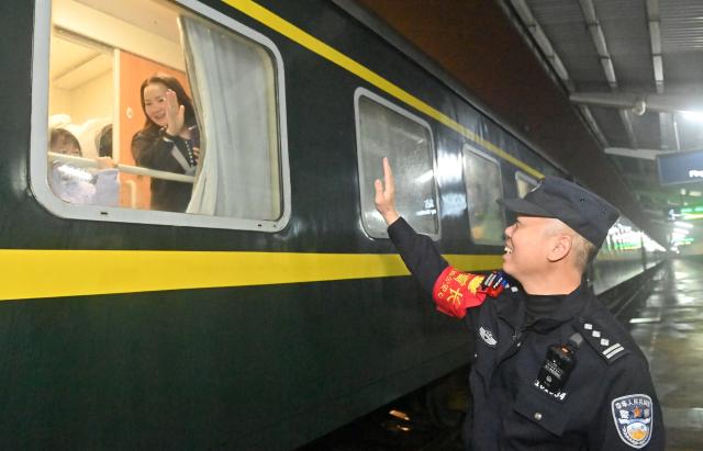 (260211) -- NANNING, Feb. 11, 2026 (Xinhua) -- Huang Qingming waves goodbye to a passenger on train No. T8701 at the Pingxiang Railway Station in Pingxiang, south China's Guangxi Zhuang Autonomous Region, Feb. 10, 2026. The China-Vietnam international passenger rail service, which resumed operations on May 25, 2025, is now facing its first Spring Festival travel rush. Huang Qingming, a 58-year-old railway police officer, has been working on this route since 2012, responsible for the Nanning-Pingxiang section of trains No. T8701 and No. T8702 in Guangxi. 
   As a railway police officer, handling various emergencies, conducting train's security check and ensuring passenger safety during the journey are part of Huang's daily routine.
   Approaching retirement, Huang cherishes his role deeply, "Serving as a railway police officer on the China-Vietnam international passenger rail service, safeguarding the trains' security and passengers' safety, has been an honorable and unforgettable experience in my career." (Xinhua/Lu Boan)