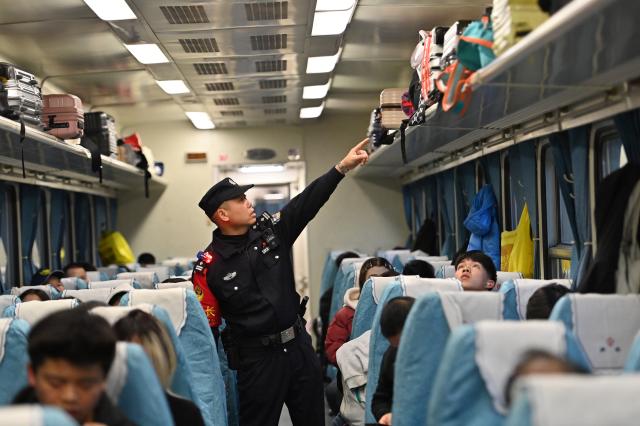 (260211) -- NANNING, Feb. 11, 2026 (Xinhua) -- Huang Qingming patrols on the train No. T8701 in south China's Guangxi Zhuang Autonomous Region, Feb. 10, 2026. The China-Vietnam international passenger rail service, which resumed operations on May 25, 2025, is now facing its first Spring Festival travel rush. Huang Qingming, a 58-year-old railway police officer, has been working on this route since 2012, responsible for the Nanning-Pingxiang section of trains No. T8701 and No. T8702 in Guangxi. 
   As a railway police officer, handling various emergencies, conducting train's security check and ensuring passenger safety during the journey are part of Huang's daily routine.
   Approaching retirement, Huang cherishes his role deeply, "Serving as a railway police officer on the China-Vietnam international passenger rail service, safeguarding the trains' security and passengers' safety, has been an honorable and unforgettable experience in my career." (Xinhua/Lu Boan)