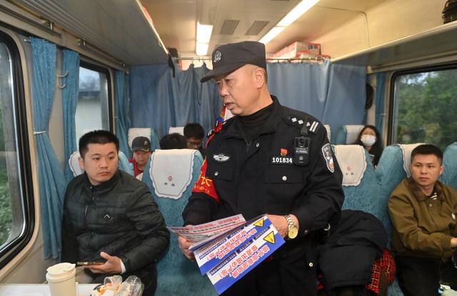 (260211) -- NANNING, Feb. 11, 2026 (Xinhua) -- Huang Qingming promotes anti-fraud awareness on the train No. T8701 in south China's Guangxi Zhuang Autonomous Region, Feb. 10, 2026. The China-Vietnam international passenger rail service, which resumed operations on May 25, 2025, is now facing its first Spring Festival travel rush. Huang Qingming, a 58-year-old railway police officer, has been working on this route since 2012, responsible for the Nanning-Pingxiang section of trains No. T8701 and No. T8702 in Guangxi. 
   As a railway police officer, handling various emergencies, conducting train's security check and ensuring passenger safety during the journey are part of Huang's daily routine.
   Approaching retirement, Huang cherishes his role deeply, "Serving as a railway police officer on the China-Vietnam international passenger rail service, safeguarding the trains' security and passengers' safety, has been an honorable and unforgettable experience in my career." (Xinhua/Lu Boan)