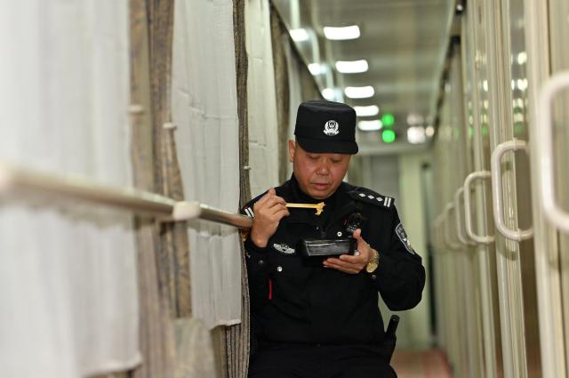 (260211) -- NANNING, Feb. 11, 2026 (Xinhua) -- Huang Qingming has dinner on the train No. T8701 in south China's Guangxi Zhuang Autonomous Region, Feb. 10, 2026. The China-Vietnam international passenger rail service, which resumed operations on May 25, 2025, is now facing its first Spring Festival travel rush. Huang Qingming, a 58-year-old railway police officer, has been working on this route since 2012, responsible for the Nanning-Pingxiang section of trains No. T8701 and No. T8702 in Guangxi. 
   As a railway police officer, handling various emergencies, conducting train's security check and ensuring passenger safety during the journey are part of Huang's daily routine.
   Approaching retirement, Huang cherishes his role deeply, "Serving as a railway police officer on the China-Vietnam international passenger rail service, safeguarding the trains' security and passengers' safety, has been an honorable and unforgettable experience in my career." (Xinhua/Lu Boan)