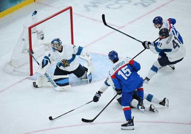 (260211) -- MILAN, Feb. 11, 2026 (Xinhua) -- Dalibor Dvorsky (bottom) of Slovakia scores during the ice hockey men's preliminary round group B match between Finland and Slovakia at the Milan-Cortina 2026 Olympic Winter Games in Milan, Italy, Feb. 11, 2026. (Xinhua/Zhang Haofu)