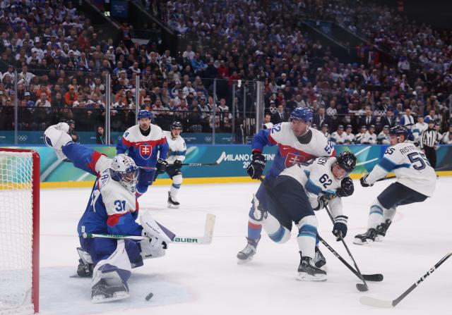 (260211) -- MILAN, Feb. 11, 2026 (Xinhua) -- Samuel Hlavaj (1st L) of Slovakia saves the puck during the ice hockey men's preliminary round group B match between Finland and Slovakia at the Milan-Cortina 2026 Olympic Winter Games in Milan, Italy, Feb. 11, 2026. (Xinhua/Wang Kaiyan)