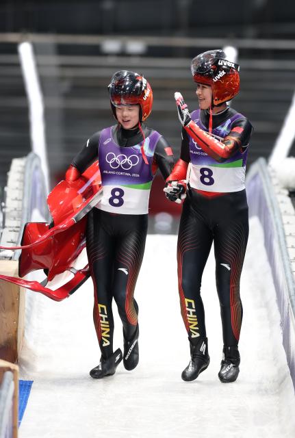 (260211) -- CORTINA D'AMPEZZO, Feb. 11, 2026 (Xinhua) -- Zhao Jiaying (L)/Gulijienaiti Adikeyoumu of China react after the luge women's doubles run 1 at the Milan-Cortina 2026 Olympic Winter Games in Cortina, Italy, Feb. 11, 2026. (Xinhua/Ding Xu)