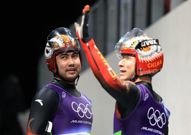 (260212) -- CORTINA D'AMPEZZO, Feb. 12, 2026 (Xinhua) -- Jubayi Saikeyi (L)/Hou Shuo of China react after the luge men's doubles run 1 at the Milan-Cortina 2026 Olympic Winter Games in Cortina, Italy, Feb. 11, 2026. (Xinhua/Ding Xu)