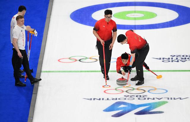 (260211) -- CORTINA D'AMPEZZO, Feb. 11, 2026 (Xinhua) -- Fei Xueqing (2nd R), Li Zhichao (3rd L) and Xu Jingtao (1st R) of China compete during the curling men round robin session 1 match between China and Britain at the Milan-Cortina 2026 Olympic Winter Games in Cortina, Italy, Feb. 11, 2026. (Xinhua/Lian Yi)
