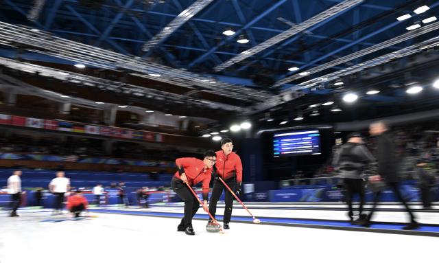 (260211) -- CORTINA D'AMPEZZO, Feb. 11, 2026 (Xinhua) -- Li Zhichao (L) of China competes during the curling men round robin session 1 match between China and Britain at the Milan-Cortina 2026 Olympic Winter Games in Cortina, Italy, Feb. 11, 2026. (Xinhua/Lian Yi)