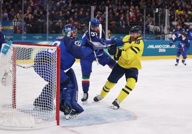 (260212) -- MILAN, Feb. 12, 2026 (Xinhua) -- Adrian Kempe (R) of Sweden vies against Phil Pietroniro (C) of Italy during the ice hockey men's preliminary round group B match between Italy and Sweden at the Milan-Cortina 2026 Olympic Winter Games in Milan, Italy, Feb. 11, 2026. (Xinhua/Wang Kaiyan)