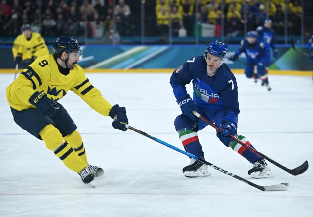 (260212) -- MILAN, Feb. 12, 2026 (Xinhua) -- Alessandro Segafredo (R) of Italy breaks through during the ice hockey men's preliminary round group B match between Italy and Sweden at the Milan-Cortina 2026 Olympic Winter Games in Milan, Italy, Feb. 11, 2026. (Xinhua/Zhang Haofu)