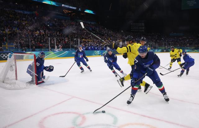 (260212) -- MILAN, Feb. 12, 2026 (Xinhua) -- Gregory di Tomaso (front R) of Italy breaks through during the ice hockey men's preliminary round group B match between Italy and Sweden at the Milan-Cortina 2026 Olympic Winter Games in Milan, Italy, Feb. 11, 2026. (Xinhua/Wang Kaiyan)