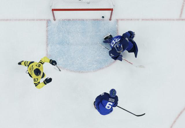 (260212) -- MILAN, Feb. 12, 2026 (Xinhua) -- Damian Clara (top) of Italy fails to save a goal during the ice hockey men's preliminary round group B match between Italy and Sweden at the Milan-Cortina 2026 Olympic Winter Games in Milan, Italy, Feb. 11, 2026. (Xinhua/Zhang Haofu)