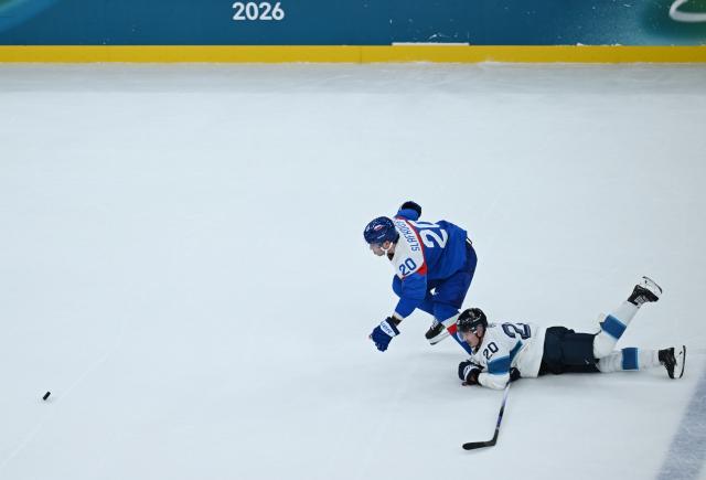 (260212) -- MILAN, Feb. 12, 2026 (Xinhua) -- Juraj Slafkovsky (L) of Slovakia breaks through during the ice hockey men's preliminary round group B match between Finland and Slovakia at the Milan-Cortina 2026 Olympic Winter Games in Milan, Italy, Feb. 11, 2026. (Xinhua/Zhang Haofu)