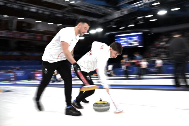 (260212) -- CORTINA D'AMPEZZO, Feb. 12, 2026 (Xinhua) -- Grant Hardie (R) of Britain competes during the curling men round robin session 1 match between China and Britain at the 2026 Milan-Cortina Winter Olympics in Cortina D'Ampezzo, Italy, Feb. 11, 2026. (Xinhua/Lian Yi)