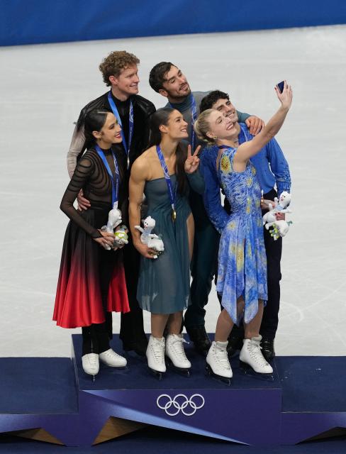 (260212) -- MILAN, Feb. 12, 2026 (Xinhua) -- Silver medalists Madison Chock and Evan Bates of the United States, gold medalists Laurence Fournier Beaudry and Guillaume Cizeron of France and bronze medalists Piper Gilles and Paul Poirier of Canada (L to R) take selfies on the podium after the free dance competition of figure skating ice dance at the Milan-Cortina 2026 Olympic Winter Games in Milan, Italy, Feb. 11, 2026. (Xinhua/Xue Yuge)