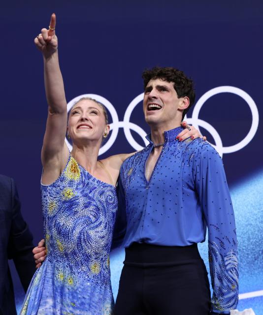 (260212) -- MILAN, Feb. 12, 2026 (Xinhua) -- Piper Gilles and Paul Poirier of Canada react as they wait for the scores during the free dance competition of figure skating ice dance at the Milan-Cortina 2026 Olympic Winter Games in Milan, Italy, Feb. 11, 2026. (Xinhua/Chen Yichen)