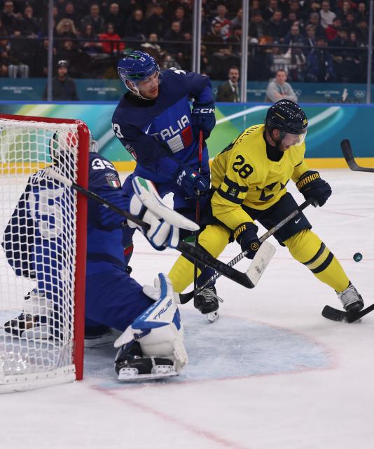 (260212) -- MILAN, Feb. 12, 2026 (Xinhua) -- Elias Lindholm (R) of Sweden competes during the ice hockey men's preliminary round group B match between Italy and Sweden at the Milan-Cortina 2026 Olympic Winter Games in Milan, Italy, Feb. 11, 2026. (Xinhua/Wang Kaiyan)