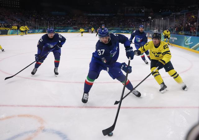 (260212) -- MILAN, Feb. 12, 2026 (Xinhua) -- Phil Pietroniro (C) of Italy competes during the ice hockey men's preliminary round group B match between Italy and Sweden at the Milan-Cortina 2026 Olympic Winter Games in Milan, Italy, Feb. 11, 2026. (Xinhua/Wang Kaiyan)