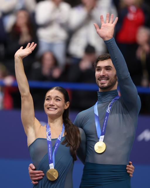 (260212) -- MILAN, Feb. 12, 2026 (Xinhua) -- Gold medalists Laurence Fournier Beaudry and Guillaume Cizeron of France react on the podium after the free dance competition of figure skating ice dance at the Milan-Cortina 2026 Olympic Winter Games in Milan, Italy, Feb. 11, 2026. (Xinhua/Chen Yichen)