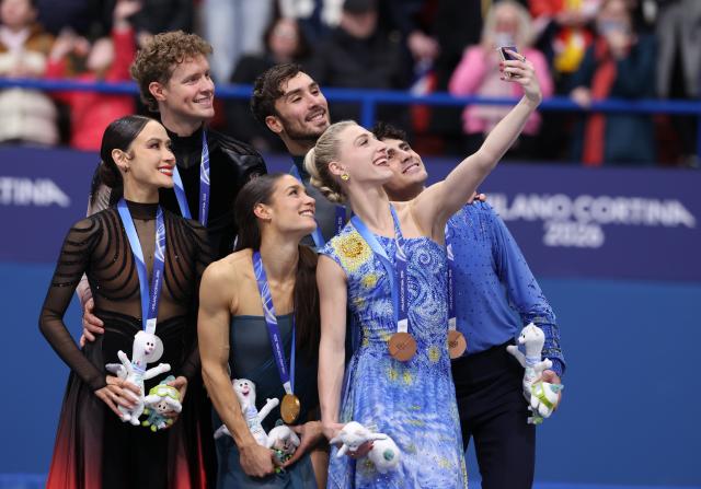 (260212) -- MILAN, Feb. 12, 2026 (Xinhua) -- Silver medalists Madison Chock and Evan Bates of the United States, gold medalists Laurence Fournier Beaudry and Guillaume Cizeron of France and bronze medalists Piper Gilles and Paul Poirier of Canada (L to R) take selfies on the podium after the free dance competition of figure skating ice dance at the Milan-Cortina 2026 Olympic Winter Games in Milan, Italy, Feb. 11, 2026. (Xinhua/Chen Yichen)