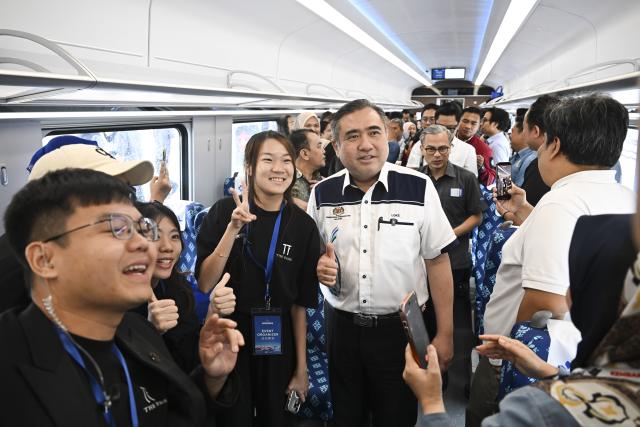 (260212) -- KUALA LUMPUR, Feb. 12, 2026 (Xinhua) -- Malaysia's Transport Minister Anthony Loke poses for photos with staff members aboard an electric multiple unit (EMU) passenger train in Pahang state, Malaysia, Feb. 11, 2026.
  As the East Coast Rail Link (ECRL), a mega rail project in Malaysia being built by the China Communications Construction Company (CCCC), moves rapidly towards completion, its first train sets for freight cargo and passengers were unveiled in Pahang state on Wednesday. (Xinhua/Cheng Yiheng)