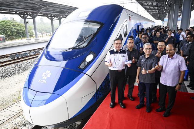 (260212) -- KUALA LUMPUR, Feb. 12, 2026 (Xinhua) -- Guests pose for photos with an electric multiple unit (EMU) passenger train in Pahang state, Malaysia, Feb. 11, 2026.
  As the East Coast Rail Link (ECRL), a mega rail project in Malaysia being built by the China Communications Construction Company (CCCC), moves rapidly towards completion, its first train sets for freight cargo and passengers were unveiled in Pahang state on Wednesday. (Xinhua/Cheng Yiheng)