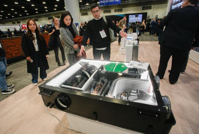 (260212) -- VANCOUVER, Feb. 12, 2026 (Xinhua) -- People look at an all-in-one heat pump at the BUILDEX 2026 trade show at the Vancouver Convention Center in Vancouver, British Columbia, Canada, on Feb. 11, 2026.
  The BUILDEX 2026 kicked off here on Wednesday. (Photo by Liang Sen/Xinhua)