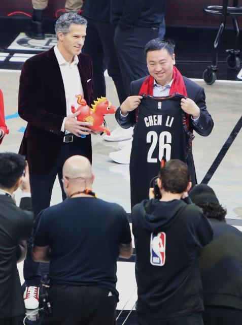 (260212) -- NEW YORK, Feb. 12, 2026 (Xinhua) -- Chinese Consul General in New York Chen Li (R) exchanges gifts with a representative from Brooklyn Nets at Barclays Center in New York, the United States, Feb. 11, 2026. (Xinhua/Zhang Fengguo)
