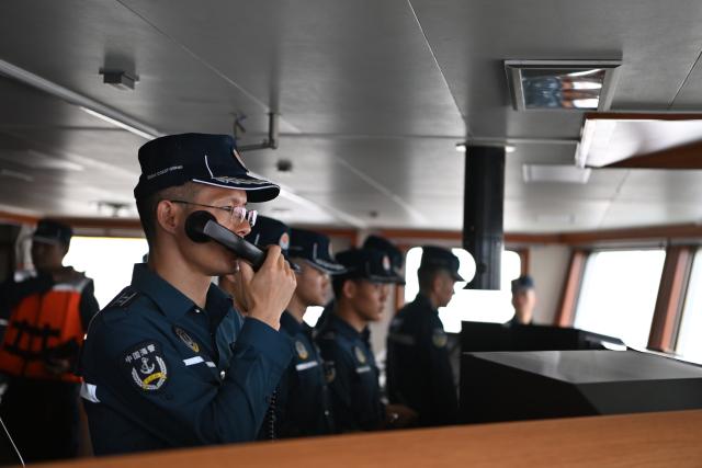 (260212) -- SOUTH CHINA SEA, Feb. 12, 2026 (Xinhua) -- A law enforcer aboard the China Coast Guard (CCG) vessel Wanshan issues navigation orders during a patrol mission in the territorial waters of China's Huangyan Dao, Feb. 6, 2026. (Photo by Zhai Yifan/Xinhua)