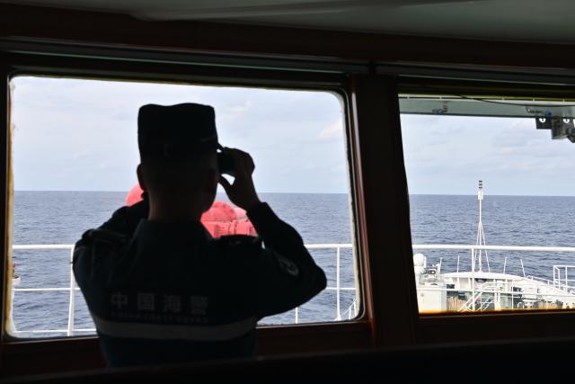 (260212) -- SOUTH CHINA SEA, Feb. 12, 2026 (Xinhua) -- A law enforcer aboard the China Coast Guard (CCG) vessel Wanshan watches out during a patrol mission in the territorial waters of China's Huangyan Dao, Feb. 6, 2026. (Photo by Zhai Yifan/Xinhua)