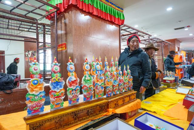 (260212) -- LHASA, Feb. 12, 2026 (Xinhua) -- A craftsman promotes butter sculptures at a stall in a local market in Lhasa, southwest China's Xizang Autonomous Region, Feb. 12, 2026. Butter sculptures in vivid shapes of trees, flowers, birds, stars, etc., are gradually gaining popularity in the markets across the city ahead of the Tibetan New Year.
   These sculptures, made skillfully with colored butter, convey people's good wishes for the New Year. (Xinhua/Tenzin Nyida)