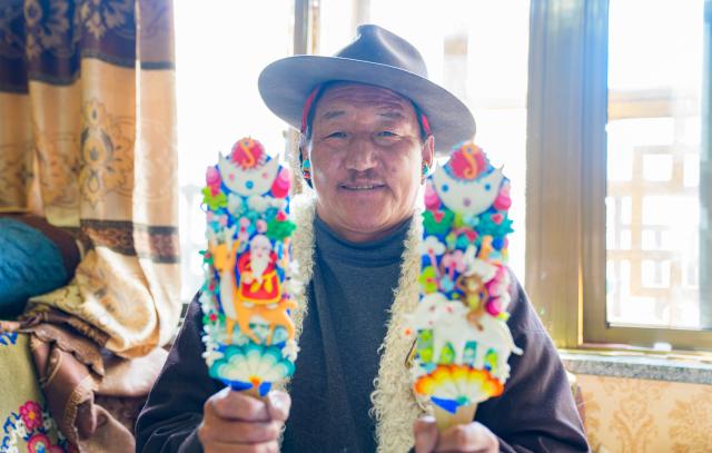 (260212) -- LHASA, Feb. 12, 2026 (Xinhua) -- A craftsman shows finished butter sculptures at a workshop in Lhasa, southwest China's Xizang Autonomous Region, Feb. 12, 2026. Butter sculptures in vivid shapes of trees, flowers, birds, stars, etc., are gradually gaining popularity in the markets across the city ahead of the Tibetan New Year.
   These sculptures, made skillfully with colored butter, convey people's good wishes for the New Year. (Xinhua/Tenzin Nyida)