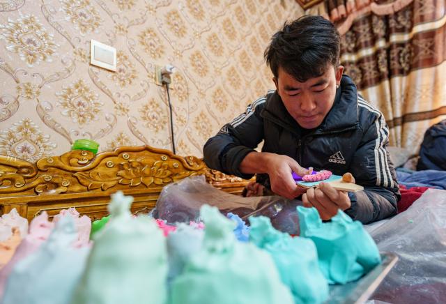 (260212) -- LHASA, Feb. 12, 2026 (Xinhua) -- A craftsman makes a butter sculpture at a workshop in Lhasa, southwest China's Xizang Autonomous Region, Feb. 12, 2026. Butter sculptures in vivid shapes of trees, flowers, birds, stars, etc., are gradually gaining popularity in the markets across the city ahead of the Tibetan New Year.
   These sculptures, made skillfully with colored butter, convey people's good wishes for the New Year. (Xinhua/Tenzin Nyida)