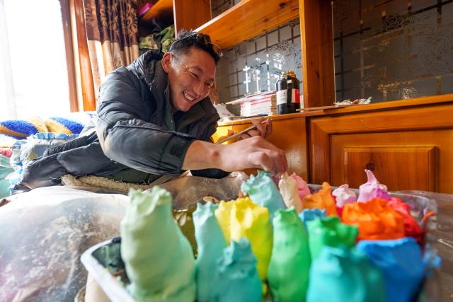 (260212) -- LHASA, Feb. 12, 2026 (Xinhua) -- A craftsman makes a butter sculpture at a workshop in Lhasa, southwest China's Xizang Autonomous Region, Feb. 12, 2026. Butter sculptures in vivid shapes of trees, flowers, birds, stars, etc., are gradually gaining popularity in the markets across the city ahead of the Tibetan New Year.
   These sculptures, made skillfully with colored butter, convey people's good wishes for the New Year. (Xinhua/Tenzin Nyida)