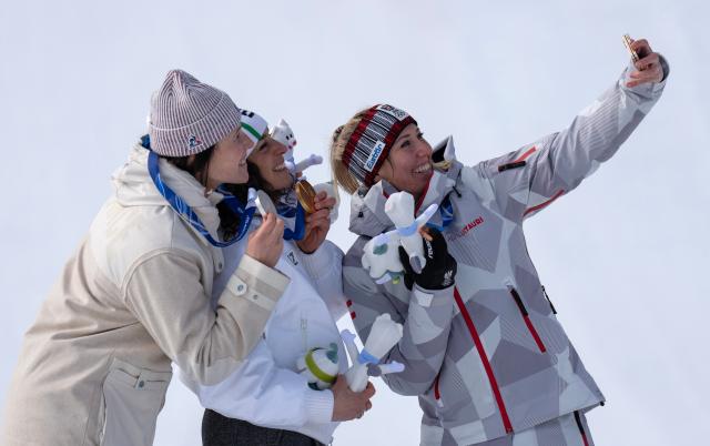 (260212) -- CORTINA D'AMPEZZO, Feb. 12, 2026 (Xinhua) -- Gold medalist Federica Brignone (C) of Italy, silver medalist Romane Miradoli (L) of France and bronze medalist Cornelia Huetter of Austria pose for a selfie during the awarding ceremony for the alpine skiing women's Super-G at the 2026 Milan-Cortina Winter Olympics in Cortina D'Ampezzo, Italy, Feb. 12, 2026. (Xinhua/Fei Maohua)