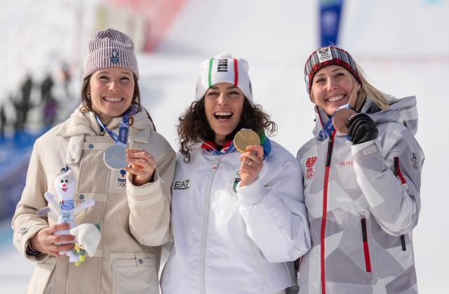 (260212) -- CORTINA D'AMPEZZO, Feb. 12, 2026 (Xinhua) -- Gold medalist Federica Brignone (C) of Italy, silver medalist Romane Miradoli (L) of France and bronze medalist Cornelia Huetter of Austria pose during the awarding ceremony for the alpine skiing women's Super-G at the 2026 Milan-Cortina Winter Olympics in Cortina D'Ampezzo, Italy, Feb. 12, 2026. (Xinhua/Fei Maohua)