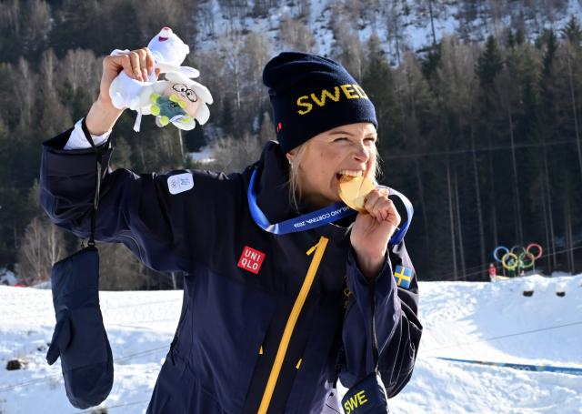 (260212) -- TESERO, Feb. 12, 2026 (Xinhua) -- Frida Karlsson of Sweden bites her medal during the awarding ceremony of the cross-country skiing women's 10km interval start free match at the Milan-Cortina 2026 Olympic Winter Games in Tesero, Italy, Feb. 12, 2026. (Xinhua/He Canling)