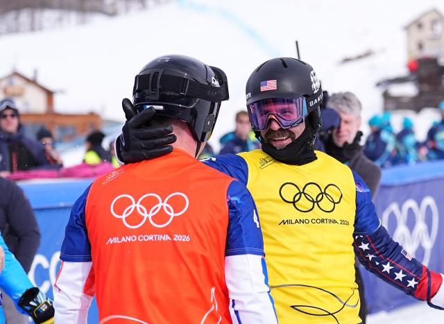 (260212) -- LIVIGNO, Feb. 12, 2026 (Xinhua) -- Nick Baumgartner (R) of the United States communicates with Jonas Chollet of France after the snowboard men's cross small final at the Milan-Cortina 2026 Olympic Winter Games in Livigno, Italy, Feb. 12, 2026. (Xinhua/Wu Huiwo)