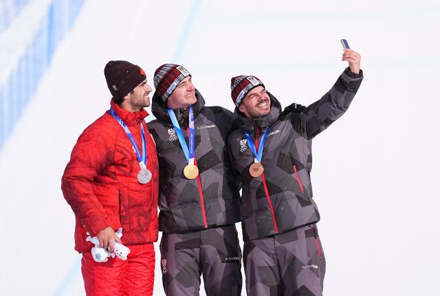 (260212) -- LIVIGNO, Feb. 12, 2026 (Xinhua) -- Gold medalist Alessandro Haemmerle (C) of Austria, silver medalist Eliot Grondin (L) of Canada and bronze medalist Jakob Dusek of Austria take a selfie during the awarding ceremony after the snowboard men's cross final at the Milan-Cortina 2026 Olympic Winter Games in Livigno, Italy, Feb. 12, 2026. (Xinhua/Wu Huiwo)