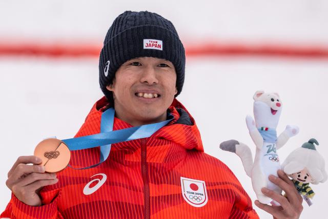 (260212) -- LIVIGNO, Feb. 12, 2026 (Xinhua) -- Bronze medalist Horishima Ikuma of Japan poses for a photo during the awarding ceremony of the freestyle skiing men's moguls match at the Milan-Cortina 2026 Olympic Winter Games in Livigno, Italy, Feb. 12, 2026. (Xinhua/Hu Chao)