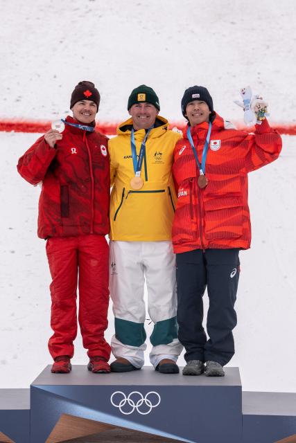 (260212) -- LIVIGNO, Feb. 12, 2026 (Xinhua) -- Gold medalist Cooper Woods (C) of Australia, silver medalist Mikael Kingsbury (L) of Canada and bronze medalist Horishima Ikuma of Japan pose for a photo during the awarding ceremony of the freestyle skiing men's moguls match at the Milan-Cortina 2026 Olympic Winter Games in Livigno, Italy, Feb. 12, 2026. (Xinhua/Hu Chao)