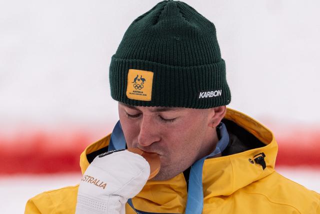 (260212) -- LIVIGNO, Feb. 12, 2026 (Xinhua) -- Gold medalist Cooper Woods of Australia kisses his medal during the awarding ceremony of the freestyle skiing men's moguls match at the Milan-Cortina 2026 Olympic Winter Games in Livigno, Italy, Feb. 12, 2026. (Xinhua/Hu Chao)