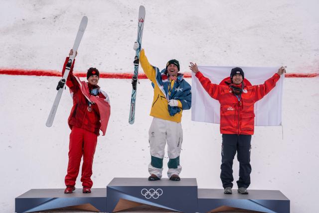 (260212) -- LIVIGNO, Feb. 12, 2026 (Xinhua) -- Gold medalist Cooper Woods (C) of Australia, silver medalist Mikael Kingsbury (L) of Canada and bronze medalist Horishima Ikuma of Japan pose for a photo during the awarding ceremony of the freestyle skiing men's moguls match at the Milan-Cortina 2026 Olympic Winter Games in Livigno, Italy, Feb. 12, 2026. (Xinhua/Hu Chao)