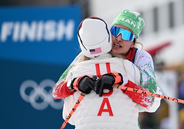 (260212) -- TESERO, Feb. 12, 2026 (Xinhua) -- Samaneh Beyrami Baher (R) of Iran hugs Jessie Diggins of the United States after the cross-country skiing women's 10km interval start free match at the Milan-Cortina 2026 Olympic Winter Games in Tesero, Italy, Feb. 12, 2026. (Xinhua/He Canling)