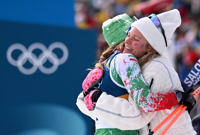 (260212) -- TESERO, Feb. 12, 2026 (Xinhua) -- Samaneh Beyrami Baher (L) of Iran hugs Jessie Diggins of the United States after the cross-country skiing women's 10km interval start free match at the Milan-Cortina 2026 Olympic Winter Games in Tesero, Italy, Feb. 12, 2026. (Xinhua/He Canling)