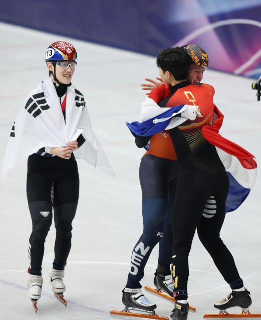 (260212) -- MILAN, Feb. 12, 2026 (Xinhua) -- Sun Long (R, front) of China hugs Jens van 'T Wout of the Netherlands after the short track speed skating men's 1000m final A at the Milan-Cortina 2026 Olympic Winter Games in Milan, Italy, Feb. 12, 2026. (Xinhua/Li Ming)